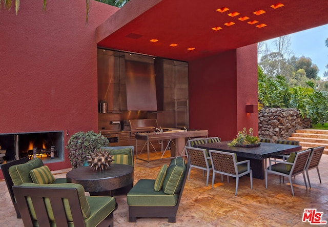 view of patio / terrace with a grill, an outdoor fireplace, and an outdoor kitchen