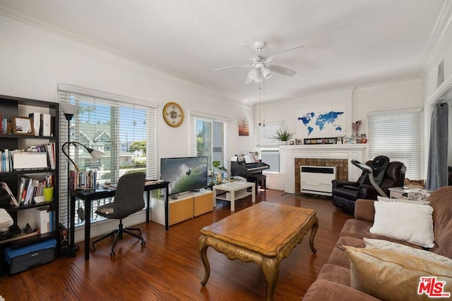 living room featuring crown molding, dark wood-type flooring, ceiling fan, and a tiled fireplace