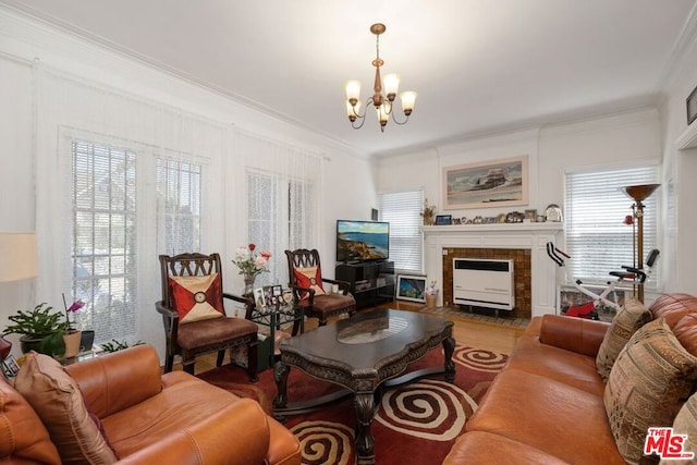 living room with a notable chandelier, a wealth of natural light, a tiled fireplace, and hardwood / wood-style flooring