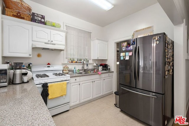 kitchen with white cabinetry, white gas range, stainless steel fridge, sink, and light tile flooring