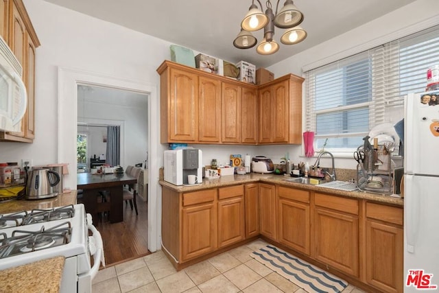 kitchen with white appliances, sink, a chandelier, and light tile flooring