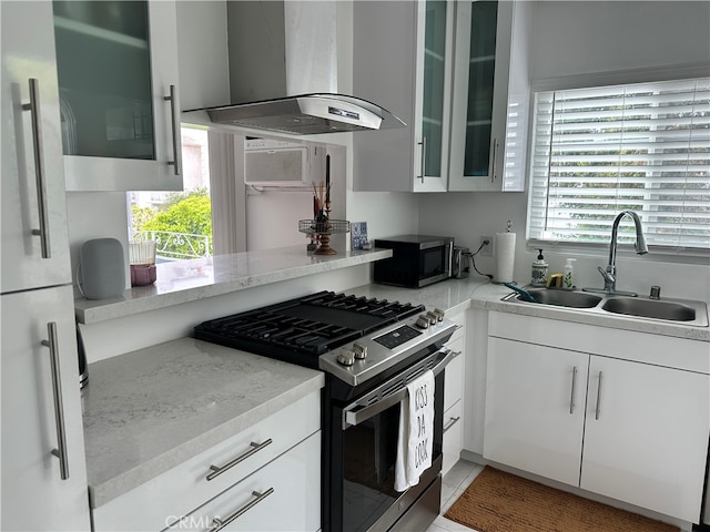 kitchen with white cabinets, stainless steel appliances, wall chimney exhaust hood, and sink