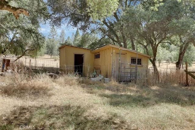 view of outdoor structure featuring an outbuilding and fence