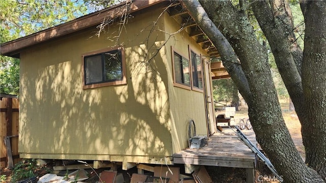 view of side of home featuring stucco siding and fence