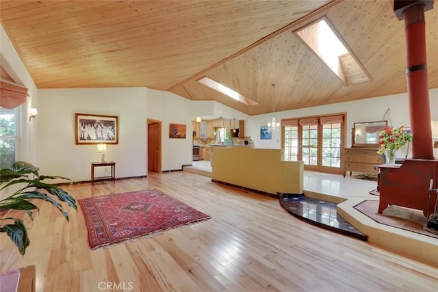 living area with vaulted ceiling with skylight, a healthy amount of sunlight, and wood finished floors