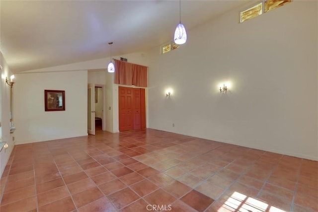 empty room featuring visible vents, light tile patterned flooring, and lofted ceiling