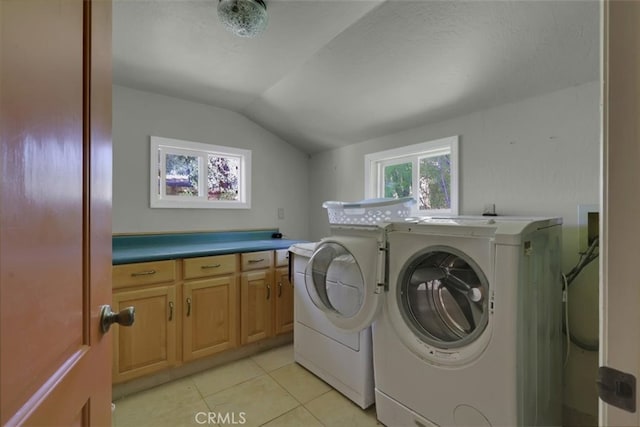 laundry room with cabinets, light tile patterned floors, and washing machine and clothes dryer