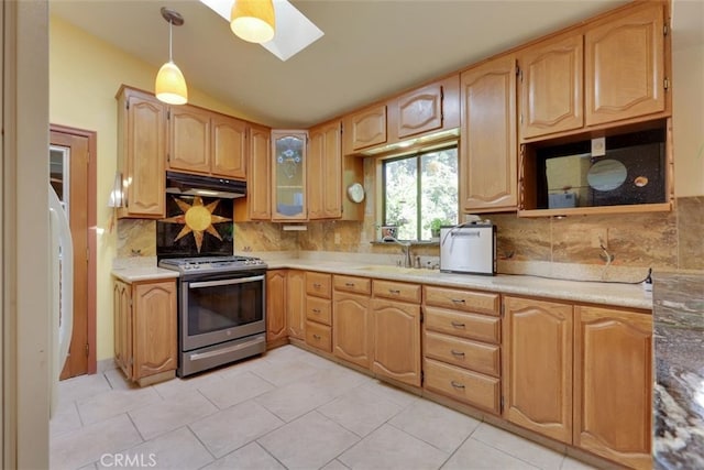 kitchen featuring decorative backsplash, light tile patterned flooring, hanging light fixtures, and stainless steel range with gas cooktop