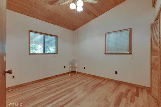 unfurnished room featuring baseboards, vaulted ceiling, a ceiling fan, light wood finished floors, and wooden ceiling
