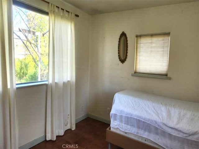 tiled bedroom featuring baseboards