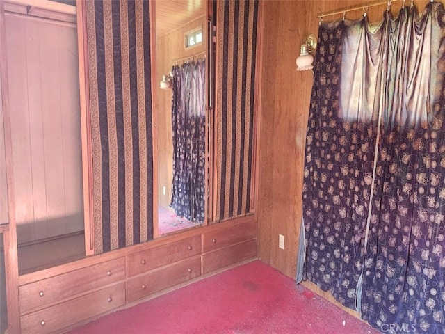 unfurnished room with wood walls and carpet flooring