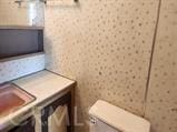 bathroom featuring vanity, wallpapered walls, and toilet