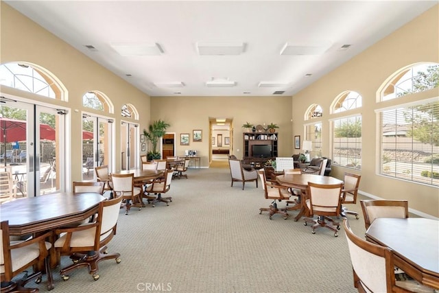 dining room with light carpet, french doors, and a healthy amount of sunlight