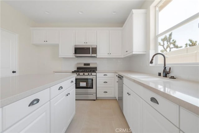 kitchen with sink, white cabinetry, appliances with stainless steel finishes, and plenty of natural light