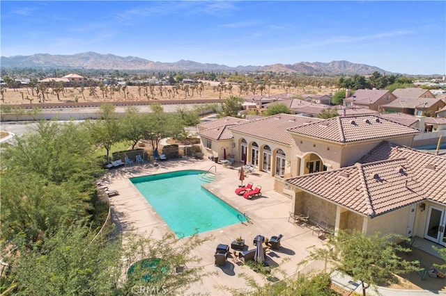 view of swimming pool with a patio area and a mountain view