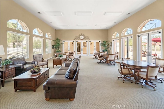 living room featuring light colored carpet, plenty of natural light, and french doors