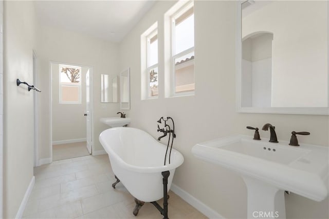 bathroom with tile patterned floors, a tub, and sink