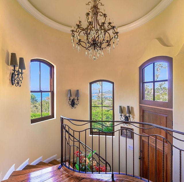 interior space with hardwood / wood-style floors, a notable chandelier, a healthy amount of sunlight, and crown molding