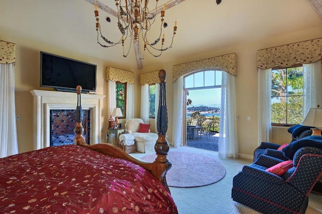 carpeted bedroom with access to outside and a notable chandelier