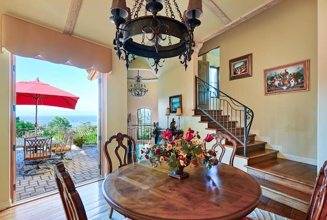 dining area featuring beamed ceiling, an inviting chandelier, and light hardwood / wood-style flooring