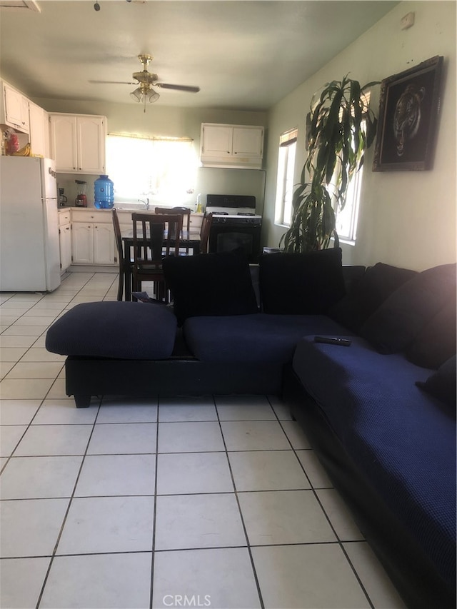 living room with ceiling fan, light tile floors, and sink