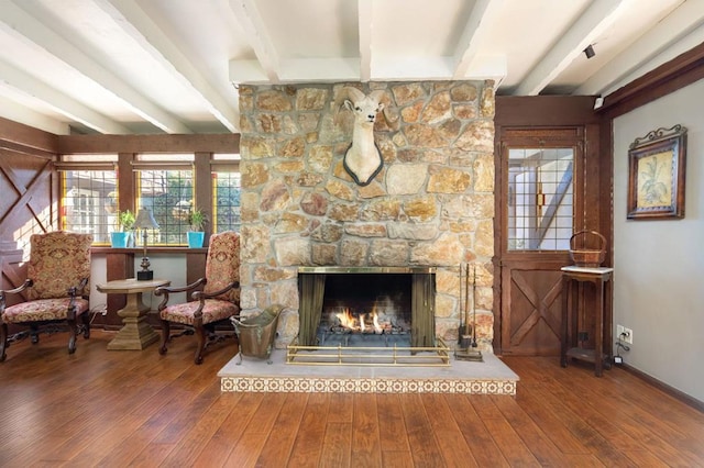 unfurnished room with beam ceiling, a fireplace, and hardwood / wood-style flooring