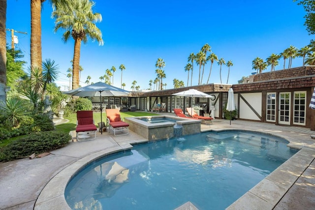 view of pool with a patio area and an in ground hot tub