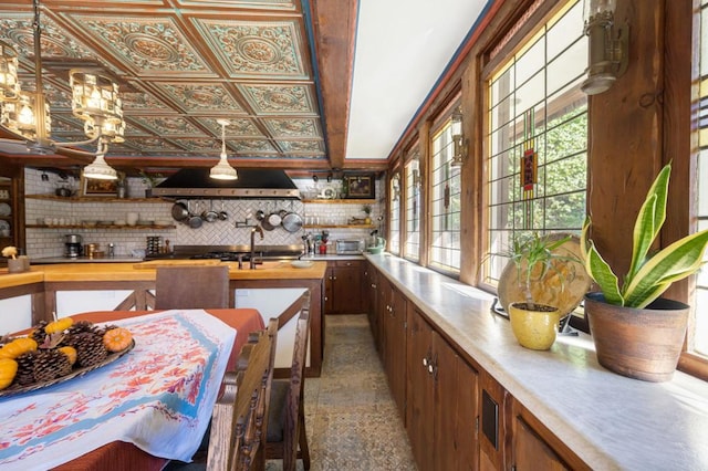 interior space with backsplash, extractor fan, and plenty of natural light