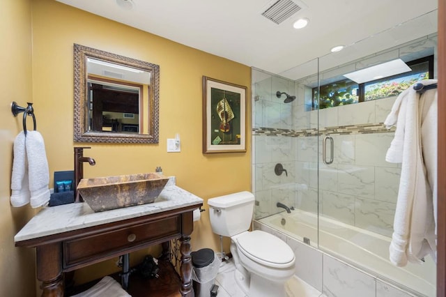 full bathroom with tile patterned flooring, vanity, enclosed tub / shower combo, and toilet