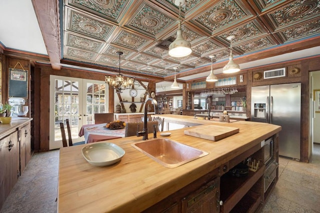 kitchen featuring french doors, stainless steel built in fridge, sink, ornamental molding, and dark brown cabinets