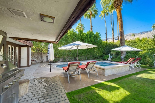 view of patio with a mountain view, a swimming pool with hot tub, and area for grilling