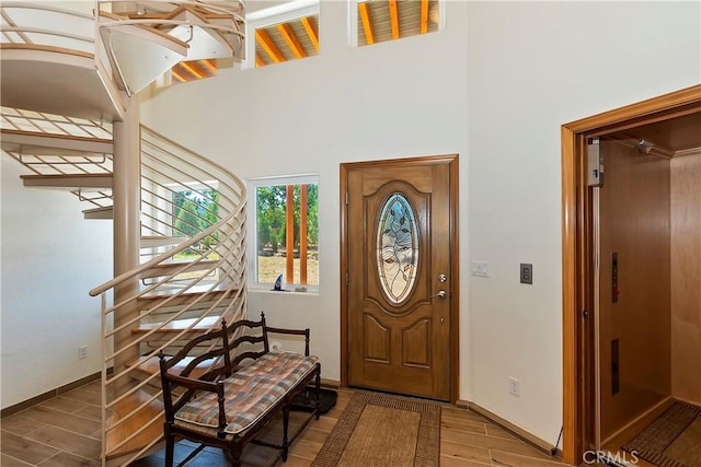 foyer with hardwood / wood-style floors and a towering ceiling