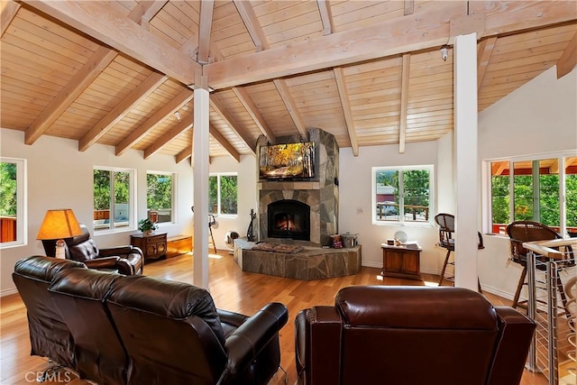 living room featuring plenty of natural light, wood ceiling, a fireplace, and light hardwood / wood-style flooring