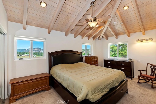 carpeted bedroom with a mountain view, ceiling fan, wooden ceiling, and lofted ceiling with beams