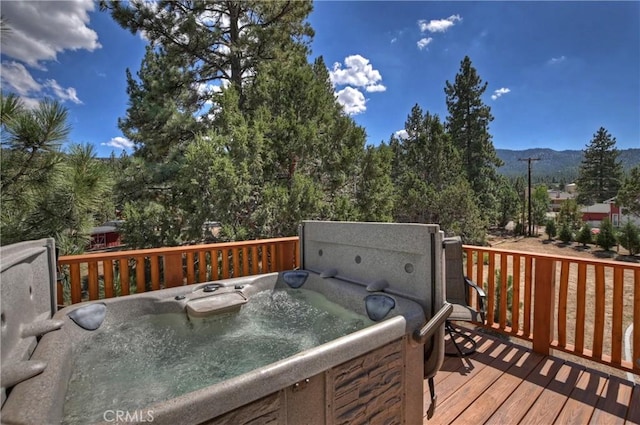 wooden terrace featuring a mountain view and a hot tub