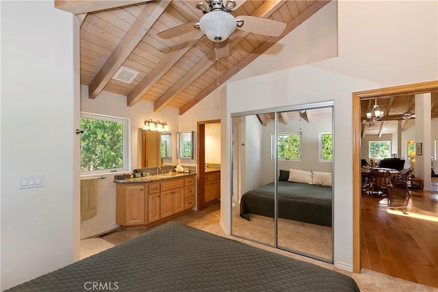 bedroom featuring ceiling fan with notable chandelier, light hardwood / wood-style flooring, multiple windows, and a closet