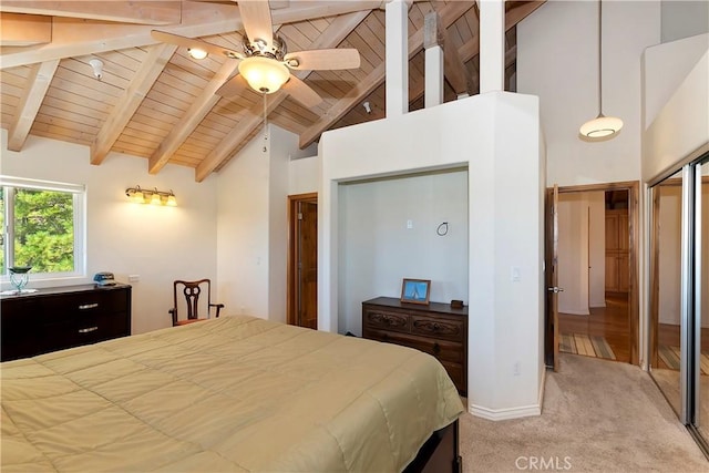 bedroom featuring light carpet, ceiling fan, high vaulted ceiling, beamed ceiling, and multiple closets