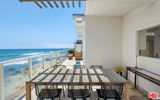 balcony featuring a beach view and a water view