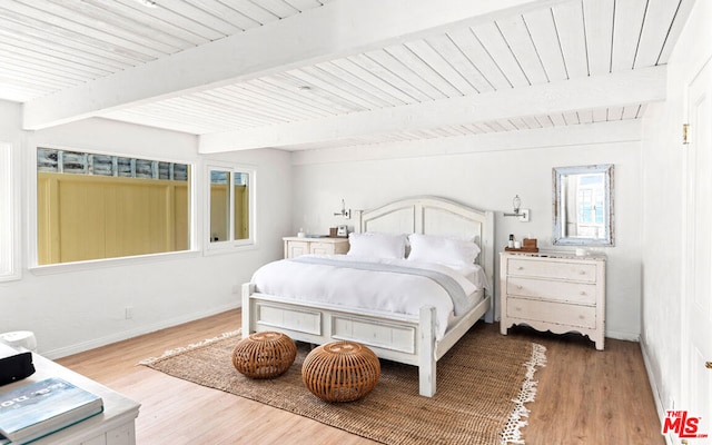 bedroom featuring beam ceiling and light hardwood / wood-style flooring