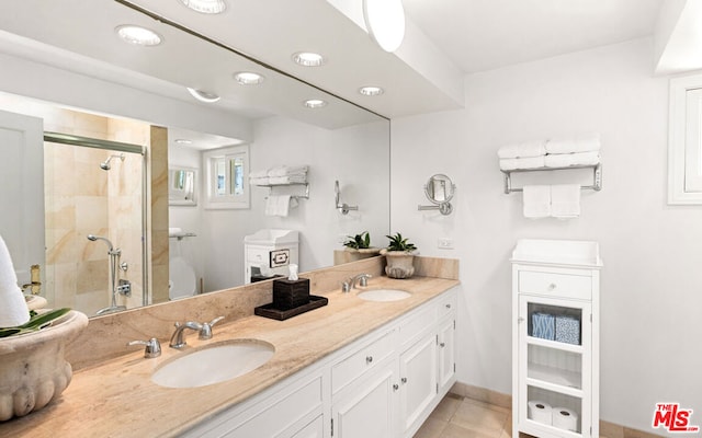 bathroom with dual sinks, vanity with extensive cabinet space, and tile flooring