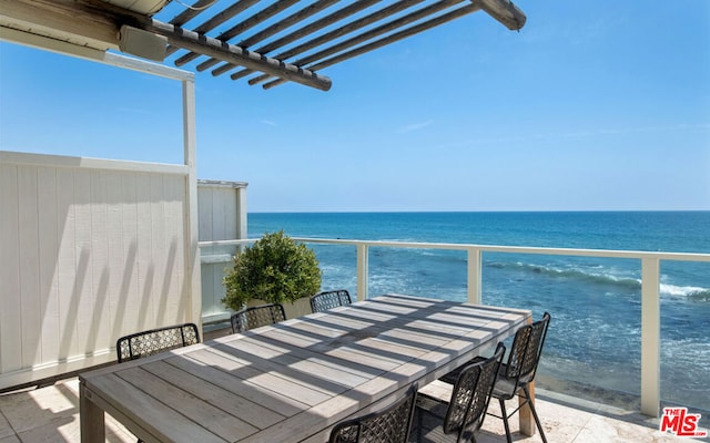 balcony featuring a water view and a pergola