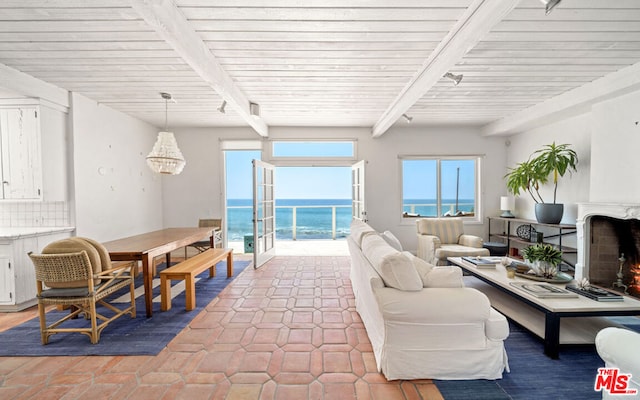 living room featuring beam ceiling, french doors, and a water view