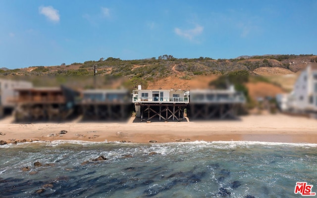 view of front of home with a beach view and a water view