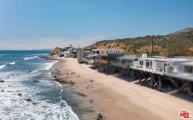 dock area featuring a water view and a view of the beach