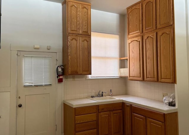 kitchen featuring backsplash, tile countertops, and sink