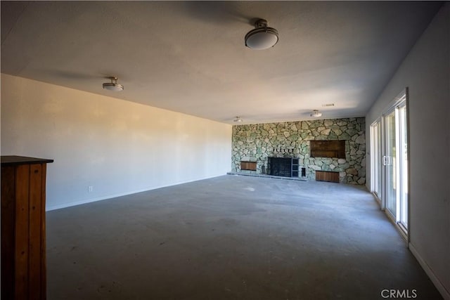 unfurnished living room featuring a stone fireplace