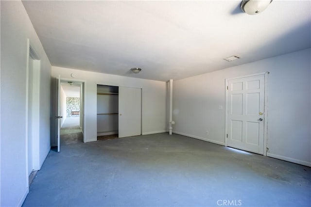 unfurnished bedroom featuring a closet and concrete floors