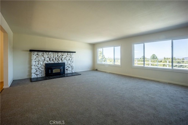 unfurnished living room featuring carpet flooring and a wood stove