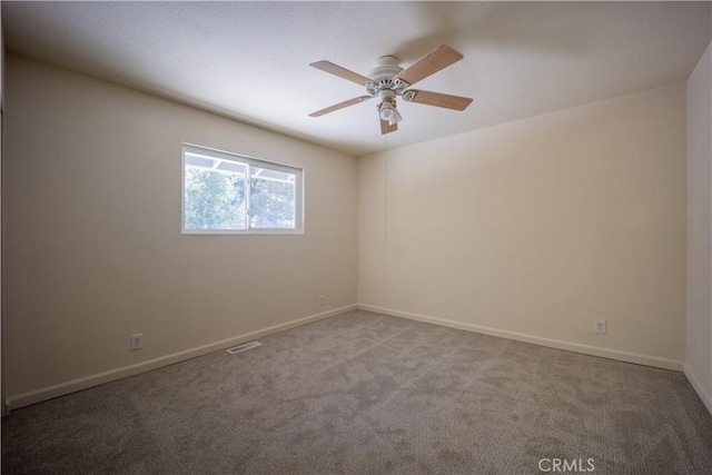 carpeted spare room with ceiling fan