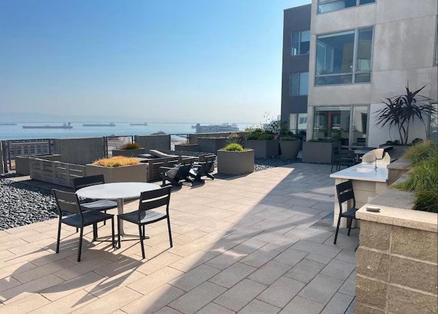 view of patio with area for grilling and a water view